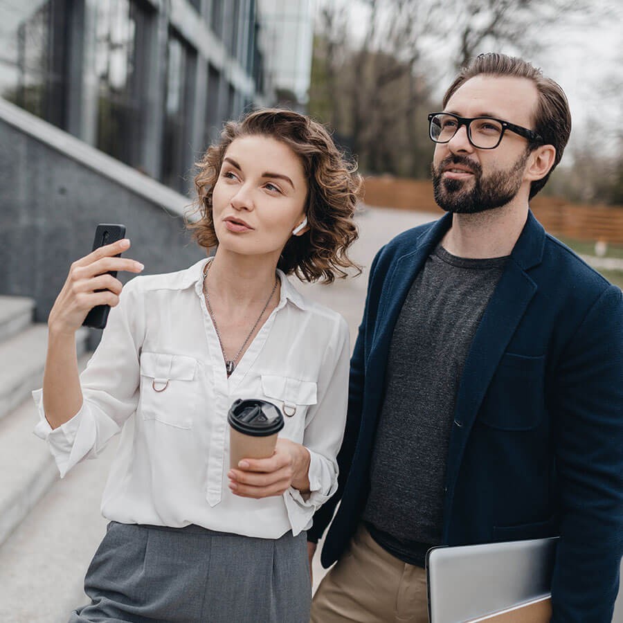 Une femme et un homme dans la rue examinant un bâtiment à acheter
